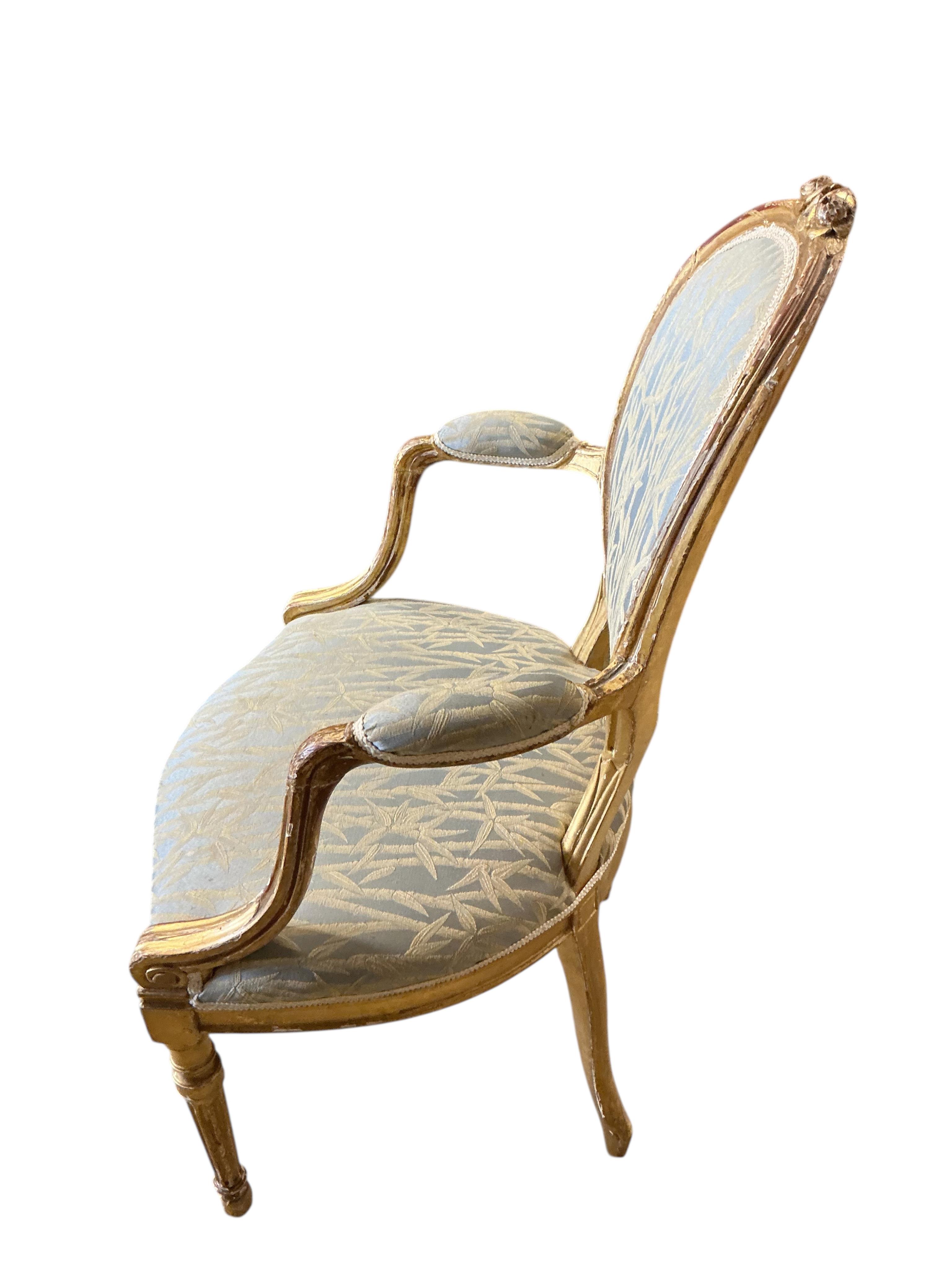 A pair of 18th century carved giltwood open elbow chairs